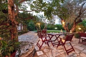 a patio with a table and chairs under a tree at Villa Ble in Skopelos Town