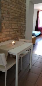 una mesa blanca y sillas con una vela en Romantic Central Flat, en Bratislava