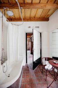 ein Badezimmer mit einer Badewanne, einem Tisch und einem Stuhl in der Unterkunft Casa del Pingone in Turin