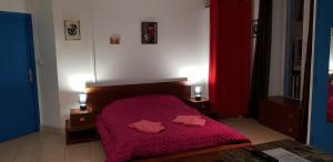 a bedroom with a red bed with two towels on it at Résidence Appartement Adonis in Nice