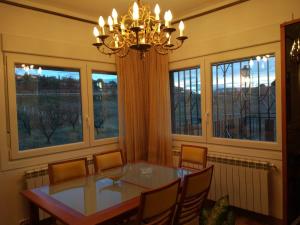 a dining room with a table and chairs and windows at Casa naranja in Teruel