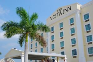 a palm tree in front of a hotel at Rio Vista Inn Business High Class Tampico in Tampico