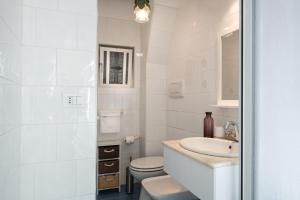 Un baño blanco con lavabo e inodoro. en Al Cedro, en Roma