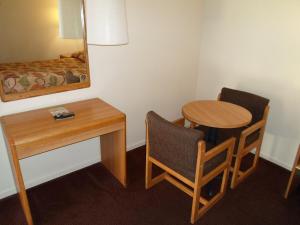 um pequeno quarto com uma mesa e uma pequena mesa e cadeira em EZ 8 Motel Newark em Newark