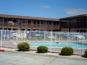 a fence in front of a building with a pool at EZ 8 Motel Newark in Newark
