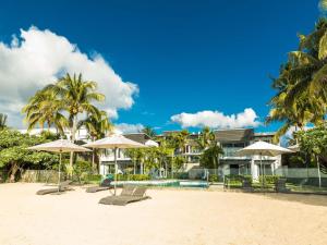 un resort con piscina, sedie e ombrelloni di AH 5-Seafront,Premium,Luxurious,Serviced Apartment a Triolet