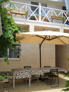 a table and chairs under an umbrella on a patio at Добрый Лев in Sukhum