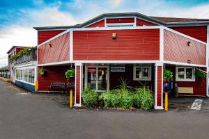 un bâtiment rouge et blanc avec des plantes devant dans l'établissement Hotel et Motel Le Chateauguay, à Québec
