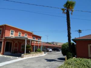 a street in a town with a palm tree and a building at Budget Inn Morgan Hill in Morgan Hill