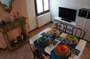 comedor con mesa con platos y TV en La Scarana, en Ferrara