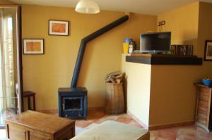 a fireplace in a living room with a stove at Casa Rebollares I in Piedralaves