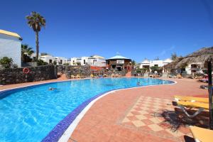 ein Pool in einem Resort mit Menschen, die darin schwimmen in der Unterkunft Fuerteventura Beach Club in Caleta de Fuste