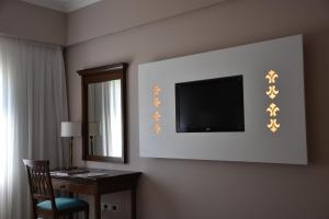 a hotel room with a desk and a television on the wall at Howard Johnson Pilar Resort Spa & Convention Center in Pilar