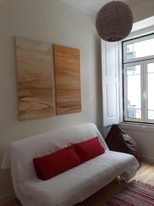 リスボンにあるLovely flat in Adamastorのリビングルーム(白いソファ、赤い枕付)