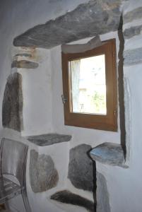 Habitación con ventana y pared de piedra. en Gite Cap de la Hont, en Laruns