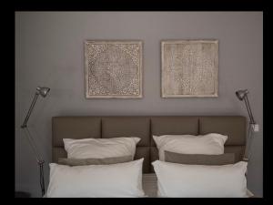 uma cama com duas almofadas e duas fotografias na parede em TM Suites em Dortmund