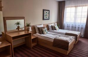 Habitación de hotel con 2 camas y escritorio en Dworek en Kolbuszowa