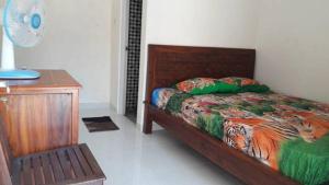 a bedroom with a bed and a nightstand and a bed sidx sidx at Arriani Homestay in Karimunjawa +9 photos