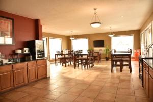 a kitchen and dining room with tables and chairs at Super 8 by Wyndham Rapid City Rushmore Rd in Rapid City