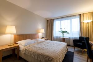 Habitación de hotel con cama, escritorio y ventana en relexa hotel Stuttgarter Hof, en Berlín