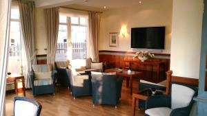 a living room with chairs and a flat screen tv at Strandhotel Juister Hof in Juist