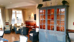 a living room with a large blue cabinet and chairs at Strandhotel Juister Hof in Juist