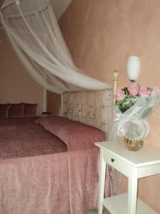 a bedroom with a bed and a table with flowers at Bed & Breakfast Giardini di Corte in Toscolano Maderno