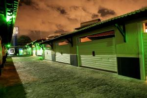 a row of green garages on a street at night at Trópicos Motel in Natal