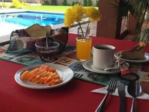 una mesa con un plato de zanahorias y una taza de zumo de naranja en Hotel Sacre, en San Juan Bautista Tuxtepec
