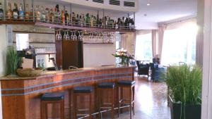 a bar with stools and wine glasses on the wall at Strandhotel Juister Hof in Juist