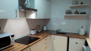 a small kitchen with white cabinets and a sink at Casa da Corisca in Vila Franca do Campo +18 photos