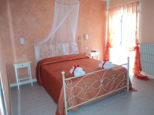 a bedroom with a bed with two stuffed animals on it at Bed&Breakfast Giardini di Corte in Toscolano Maderno