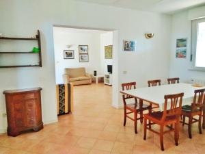 - un salon avec une table, des chaises et un canapé dans l'établissement Villa Eucalipti, à Scarlino
