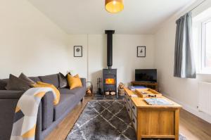 a living room with a couch and a wood stove at The Hideaway in Stratford-upon-Avon