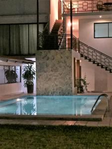 a swimming pool in front of a house at night at Hotel Sacre in San Juan Bautista Tuxtepec
