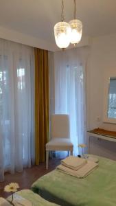 a bedroom with a bed and a chair and a chandelier at NN Luxury Room near Athens Airport in Spáta