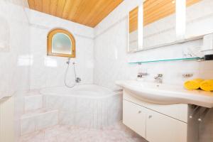 biała łazienka z wanną i umywalką w obiekcie Landhaus Pfurtscheller w Neustift im Stubaital