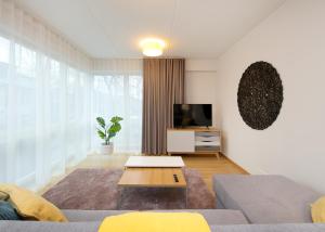 a living room with a couch and a tv at TP City Apartment - City Center in Tallinn