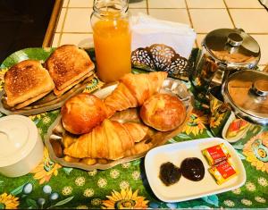 a table topped with plates of pastries and orange juice at Chambre d'Hôtes Casa Mia in Belvédère +18 photos