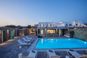 a villa with a swimming pool at night at Mando Pool Villas w Sea Views - Five Bedrooms in Super Paradise Beach