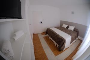 a bedroom with a bed and a bathroom with a television at Bagu Playa Grande Hotel in Mar del Plata