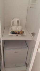 a white cabinet with two cups on top of it at NN Luxury Room near Athens Airport in Spata