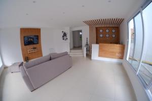 a living room with a couch and a large window at Bagu Playa Grande Hotel in Mar del Plata