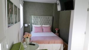 a bedroom with a large bed with pink pillows at By the Sea in Nazaré