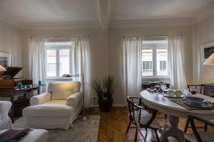 リスボンにあるBelem Riverside Charming Apartmentのリビングルーム(白い椅子、テーブル付)