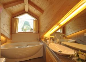 a bathroom with a large tub and a sink at Romantic Chalet Dolomiti in Val di Zoldo +10 photos