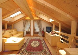 a living room with a couch and a tv at Romantic Chalet Dolomiti in Val di Zoldo