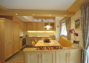 a kitchen with wooden cabinets and a table with flowers on it at Romantic Chalet Dolomiti in Val di Zoldo