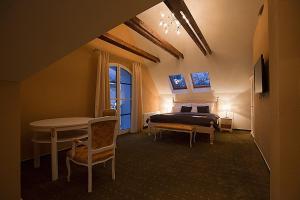 a bedroom with a bed and a table in a room at Old House in Hradec nad Moravici