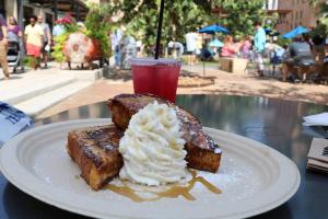 a white plate with a piece of cake and whipped cream at Hays St Cozy Remodeled 2BR/2BA house sleeps 8 in San Antonio